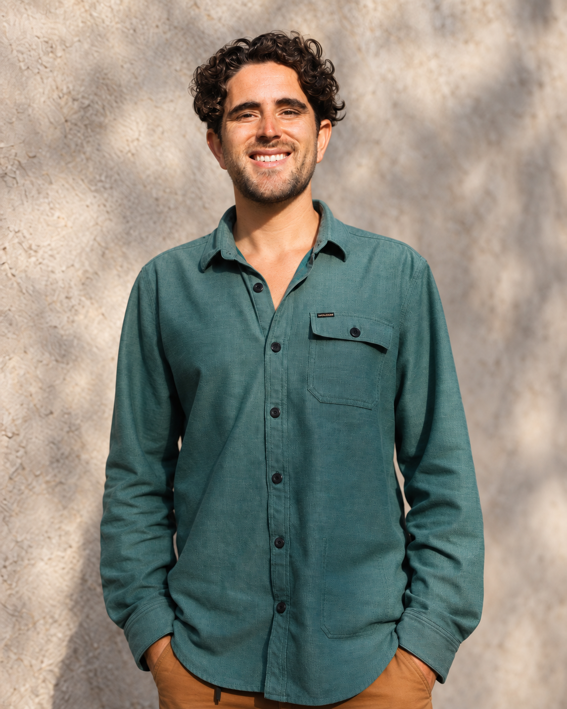 Nick Catton smiling in a green shirt and tan trousers